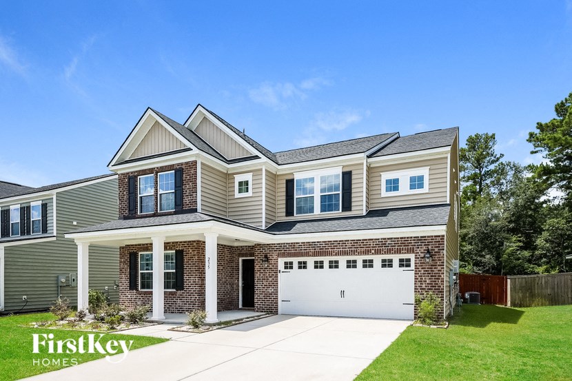 A two-story house with a garage is showcased in the image.