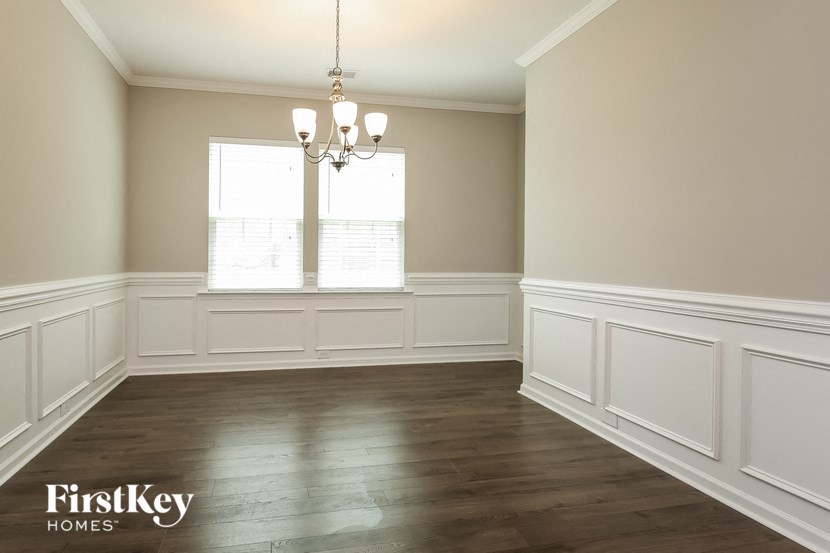 A room with wooden floors and a chandelier hanging from the ceiling.
