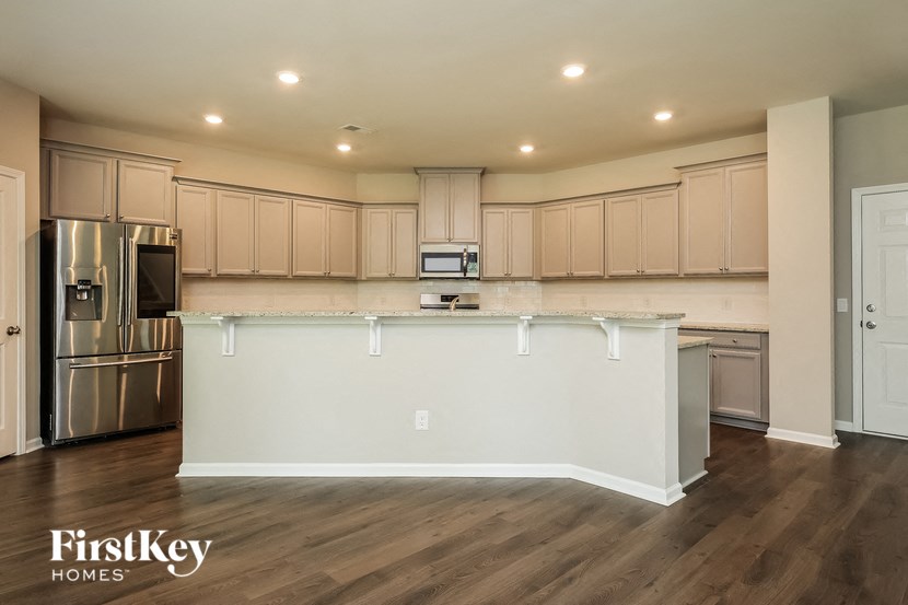 A kitchen with wooden cabinets and a stainless steel refrigerator.