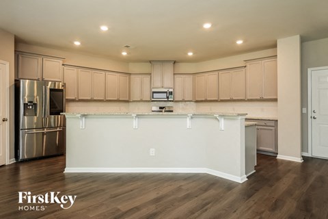 A kitchen with wooden cabinets and a stainless steel refrigerator.
