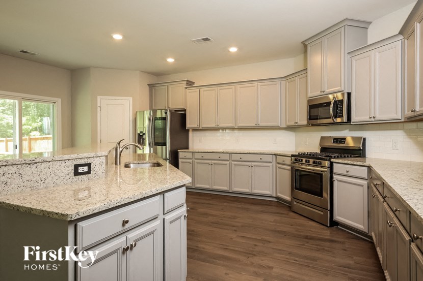 A kitchen with a granite countertop and wooden floors.