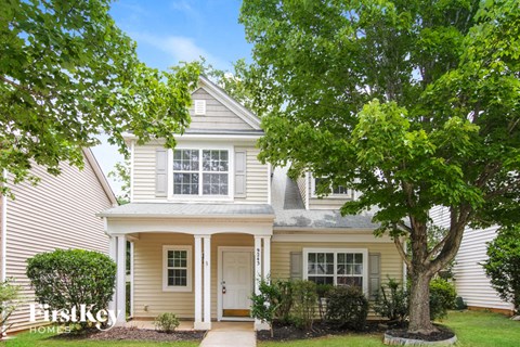 a white house with a tree in front of it