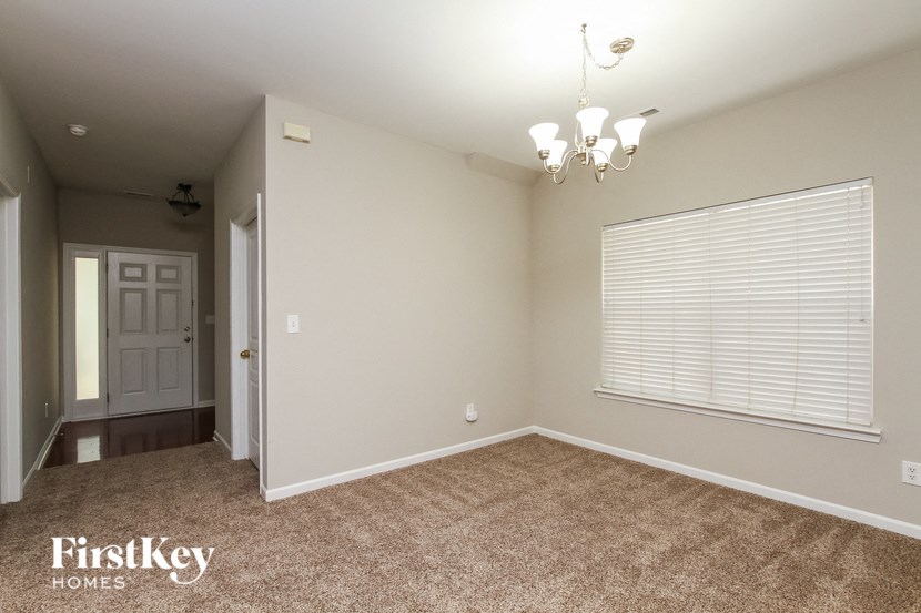 a bedroom with a large window and a carpeted floor