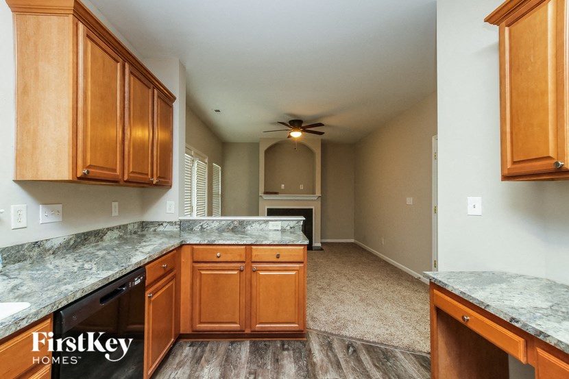 an empty kitchen with wood cabinets and granite counter tops
