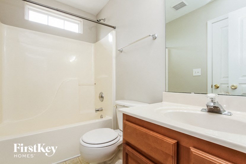 a bathroom with a sink toilet and shower and a mirror