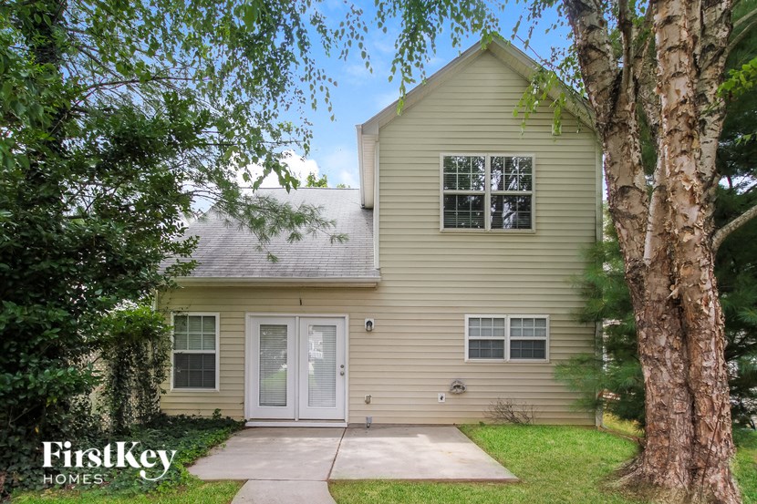 the exterior of a home with trees and a sidewalk