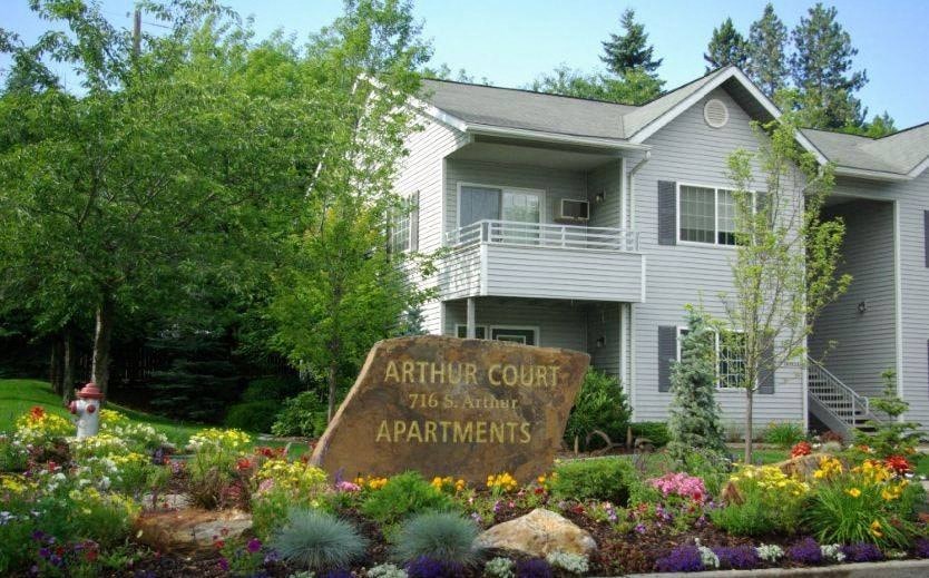 A sign in front of a building that says Arthur Court Apartments.