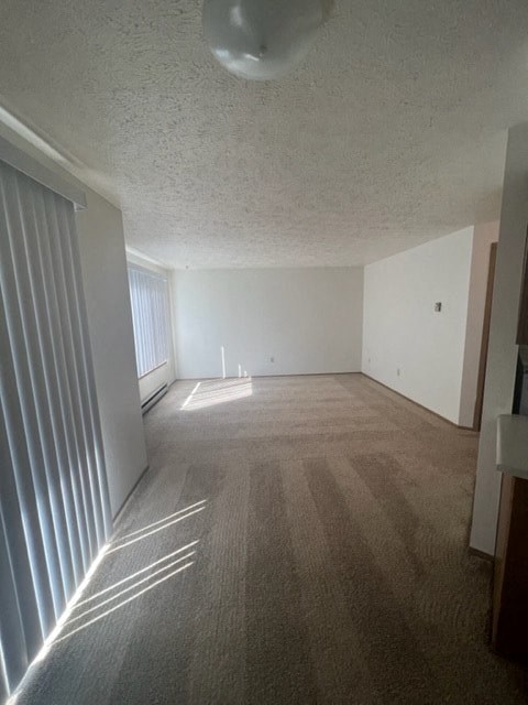 an empty living room with white walls and a window