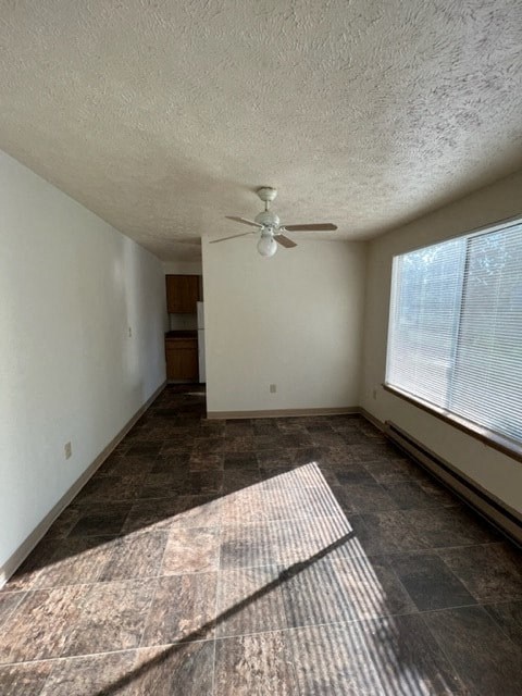 an empty living room with a ceiling fan and a large window