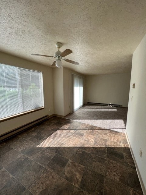 an empty living room with a ceiling fan and a large window