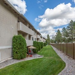 an apartment building with a yard and grass next to it
