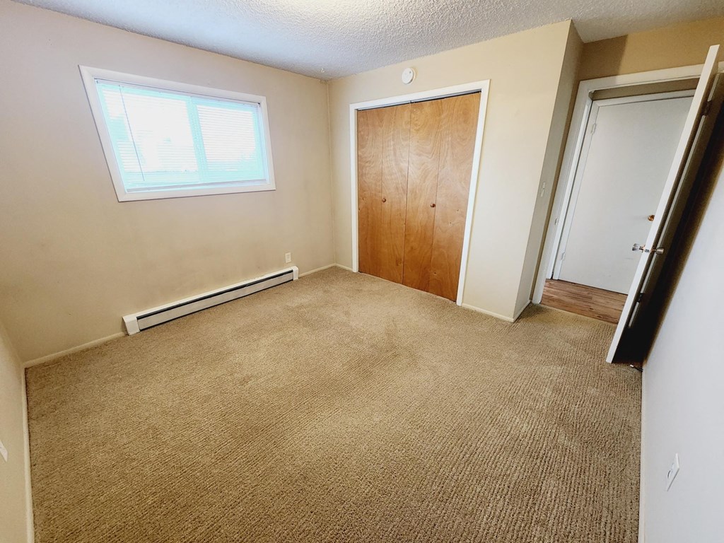an empty room with a carpeted floor and a door