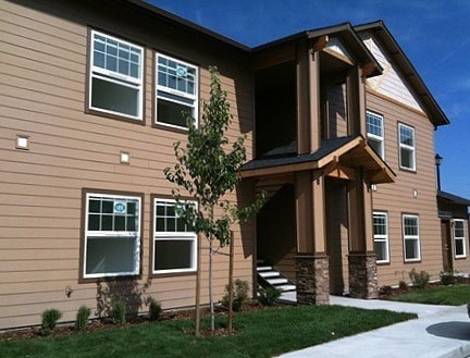A house with a brown siding and a white window.
