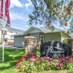 a house with a sign and flowers in front of it