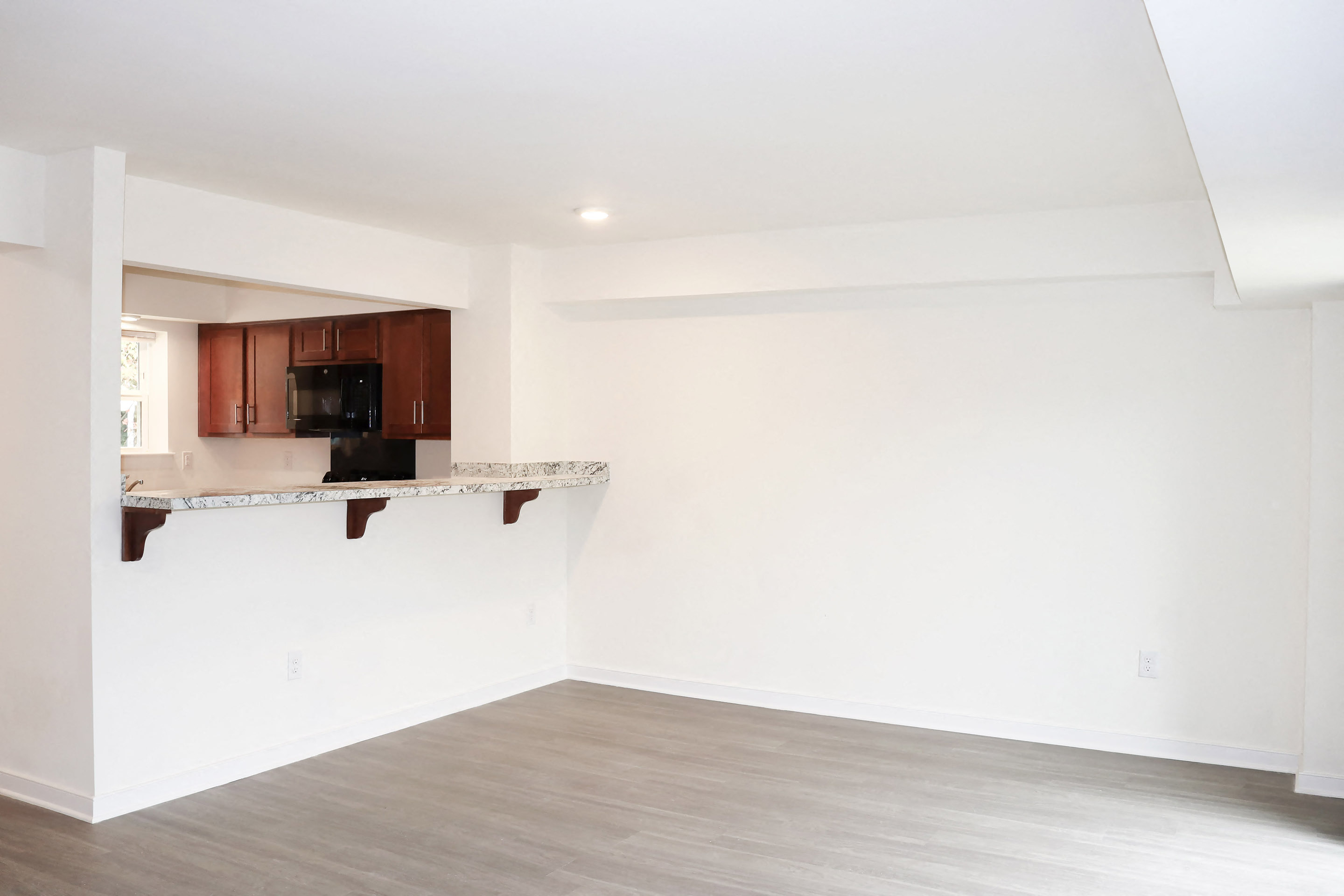 an empty room with a kitchen and a counter top