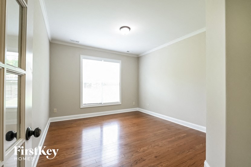 an empty room with wood floors and a window