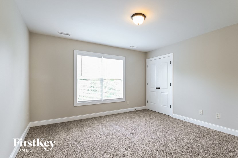 a bedroom with carpet and a window and a door