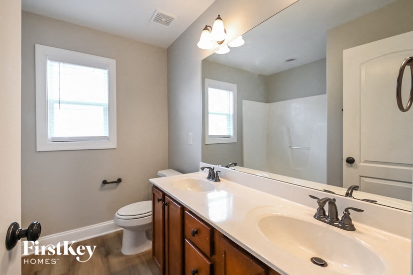 the master bathroom has a large vanity with two sinks and a toilet