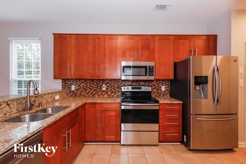 A kitchen with wooden cabinets and a stainless steel refrigerator.