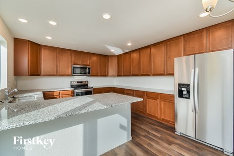 a kitchen with wooden cabinets and a granite counter top