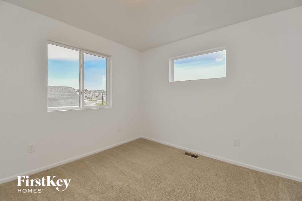 a white room with two windows and a carpet