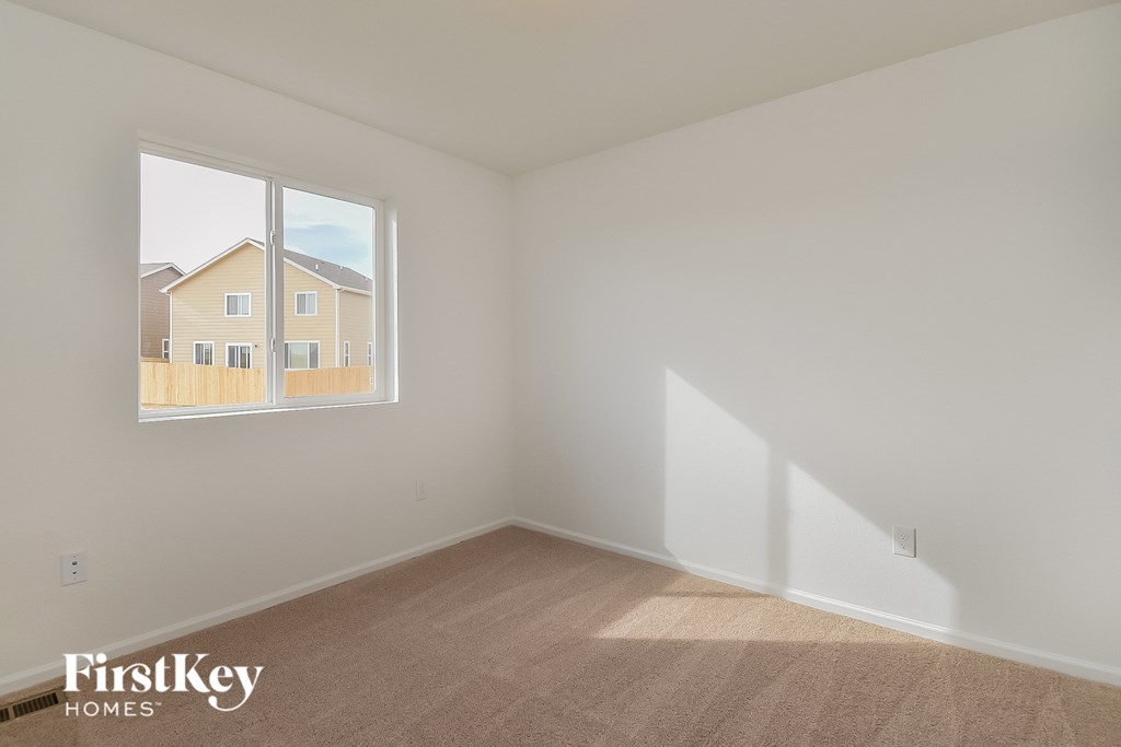 a bedroom with a large window and white walls