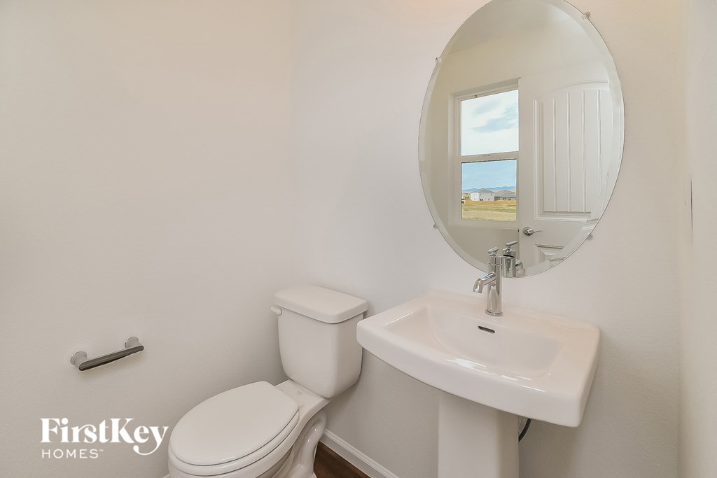 a bathroom with a toilet and a sink and a mirror