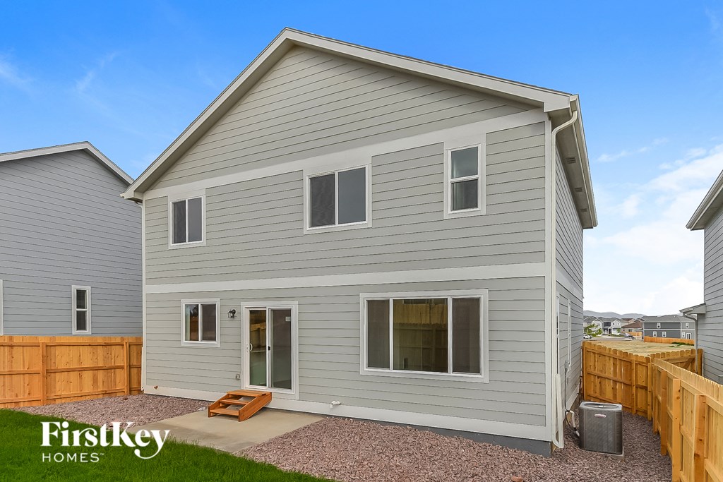 a gray house with a backyard and a wooden fence