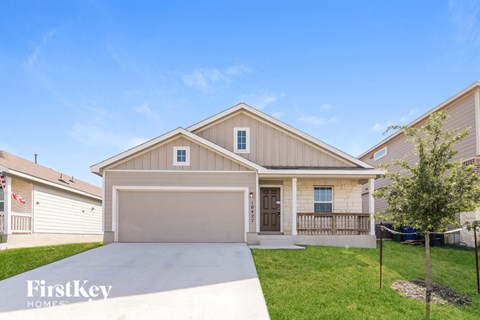 a beige and tan house with a driveway and grass