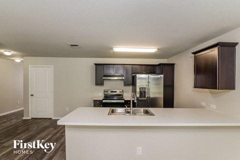 a kitchen with a sink and a stainless steel refrigerator