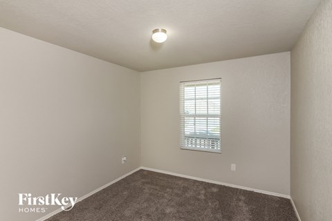 the upstairs bedroom with carpet and a window