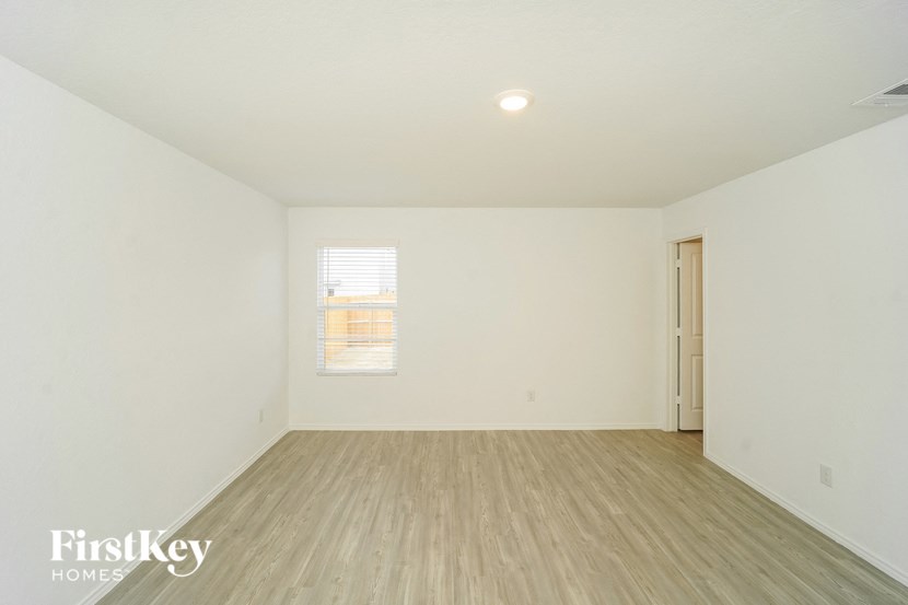 an empty living room with white walls and wood floors