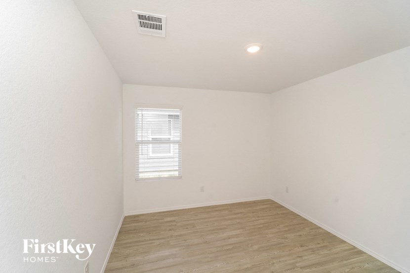 the spacious living room with wood flooring and a window