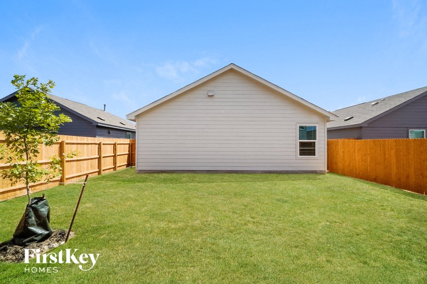 a backyard with a house and a fence