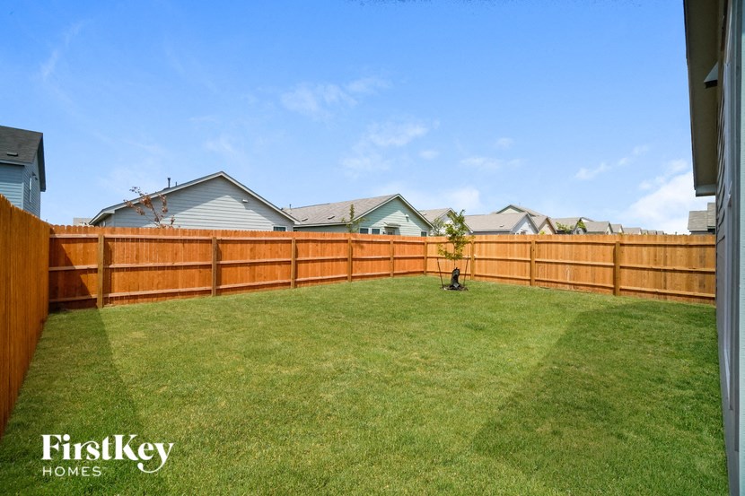 a wooden fence in a backyard with a lawn