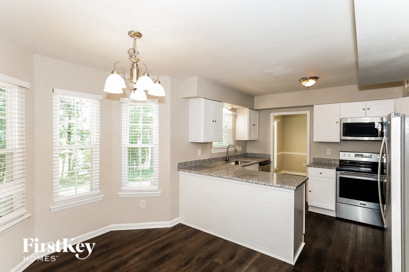 A kitchen with a granite countertop and stainless steel appliances.