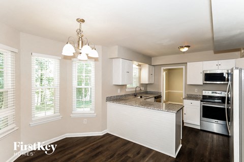 A kitchen with a granite countertop and stainless steel appliances.