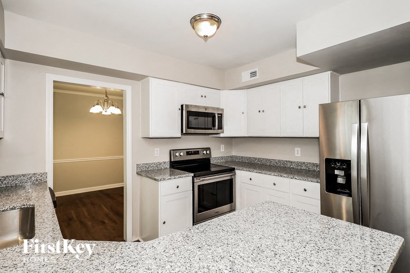 A kitchen with a granite countertop and stainless steel appliances.
