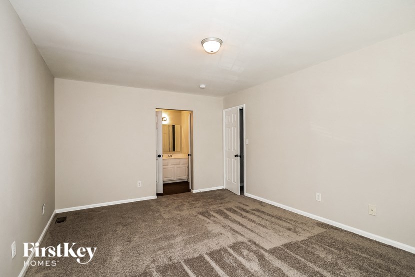 A room with a carpeted floor and a doorway leading to another room.