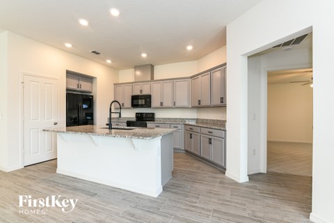 A kitchen with a white island and wooden cabinets.