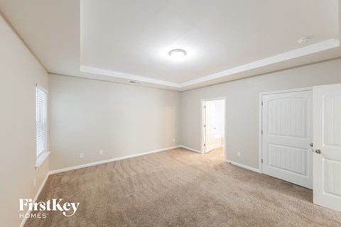 a spacious living room with carpet and white doors