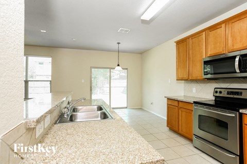 A kitchen with a sink, stove, and microwave.