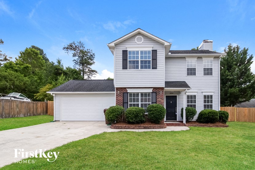 a white house with a lawn and a driveway