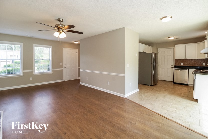 an empty kitchen and living room with a ceiling fan
