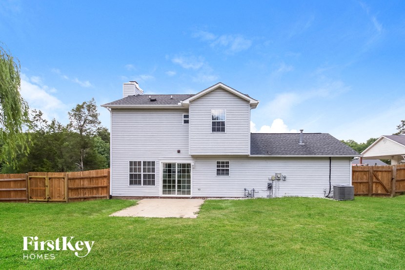 a white house with a yard and a wooden fence