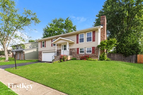 a house with a lawn and a sidewalk in front of it