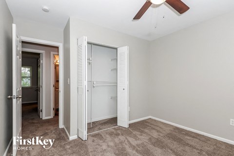 a bedroom with a closet and a ceiling fan