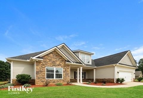 A house with a stone facade and a large front yard.