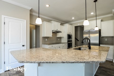 A kitchen with granite countertops and white cabinets.