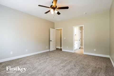 A spacious room with a ceiling fan and two doors.
